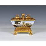 A Continental porcelain sarcophagus shaped inkstand the curved sides with painted country scenes, on