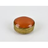 A gilt metal and amber butterscotch trinket box of oval form, having convex amber butterscotch cover