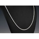 An 18ct white gold and diamond line necklace the brilliant cut diamonds totalling 15.50ct, 21in. (