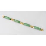 A Chinese 14ct yellow gold and jade bracelet the four curved mottled pale green jade links divided