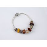 A Pandora sterling silver Moments bracelet fitted with nine silver and wooden charms, the silver