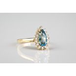 A 14ct yellow gold, blue topaz and diamond cluster ring the pear cut topaz within a border of