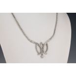 A 14ct white gold and diamond necklet the bright cut and beaded necklace with a central tied