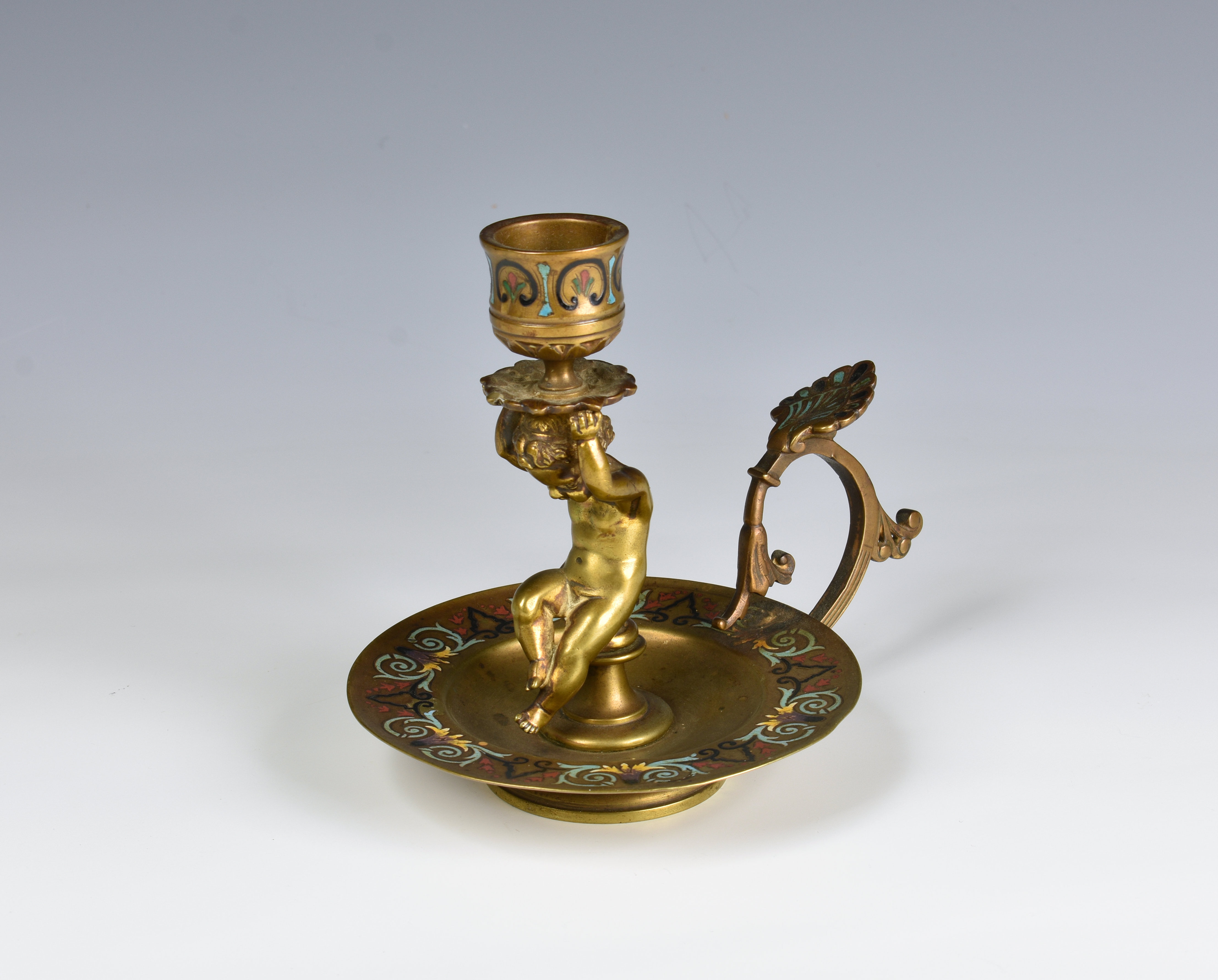 A 19th century French gilt bronze and champleve enamel chamberstick the urn sconce carried by a