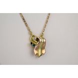 A 9ct two colour rose and yellow gold, emerald and diamond necklace the scrolled setting with two
