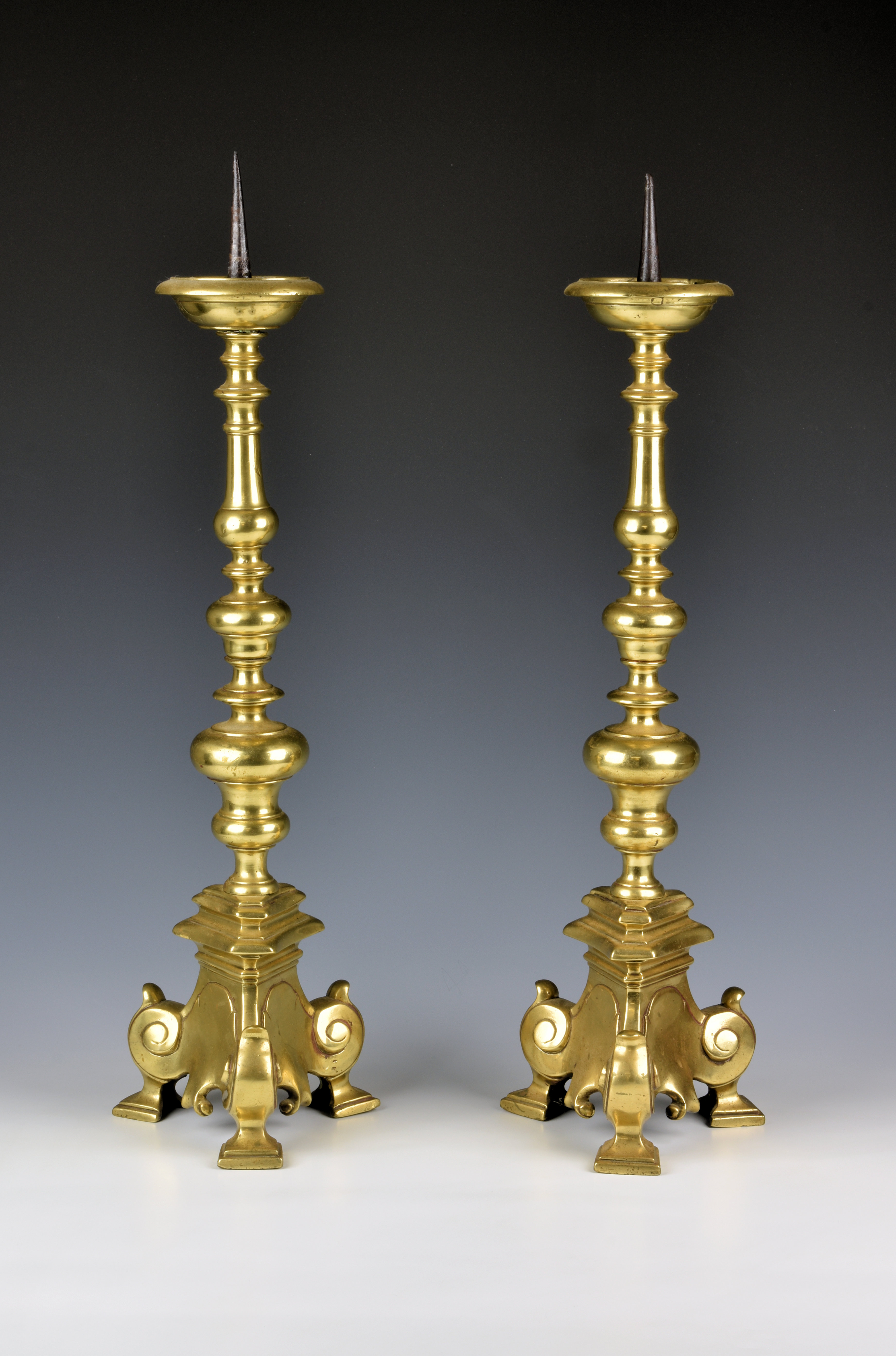 A pair of 17th / 18th century Flemish brass pricket candlesticks each with a circular drip pan