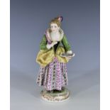 A Meissen style figure of a girl holding a music book early 20th century, Continental, in a green