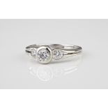 An 18ct white gold and diamond three stone ring the central brilliant cut diamond over pierced