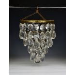 A vintage five tier bag chandelier 1920s-30s, the gilt metal foliate top tier suspending teardrop