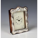 A modern silver mounted wooden table clock Carr's of Sheffield Ltd., 1991, the shaped silver mount