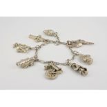 A silver charm bracelet with textured links and nine charms.