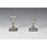 A pair of late Victorian dwarf candlesticks Charles Stuart Harris, London 1898, the stepped square