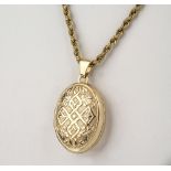 A 9ct gold Victorian style locket with strapwork decoration, on a 9ct gold rope twist chain.