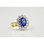 An 18ct white and yellow gold, sapphire and diamond cluster ring the central oval cut sapphire of