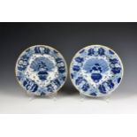 A matched pair of Delft blue and white 'Peacock' pattern dishes 18th century, painted with a fan