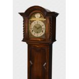 A 1930s oak grandmother clock with eight day musical movement, the brass arched dial with silvered