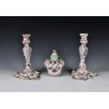 A pair of Continental porcelain rococo candlesticks c.1900, the shaped triangular based candlesticks