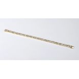 An 18ct yellow gold and diamond bracelet with baguette and brilliant cut diamond links, the