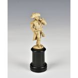 A small carved ivory figure of an 18th century gentleman in officer's great coat and tricorn hat the