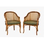 A pair of faux bamboo Bergere style tub chairs by Grange with green leather squab cushion, raised on