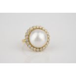 An 18ct yellow gold, Mabé pearl and diamond dress ring the 17mm. pearl within a border of 22