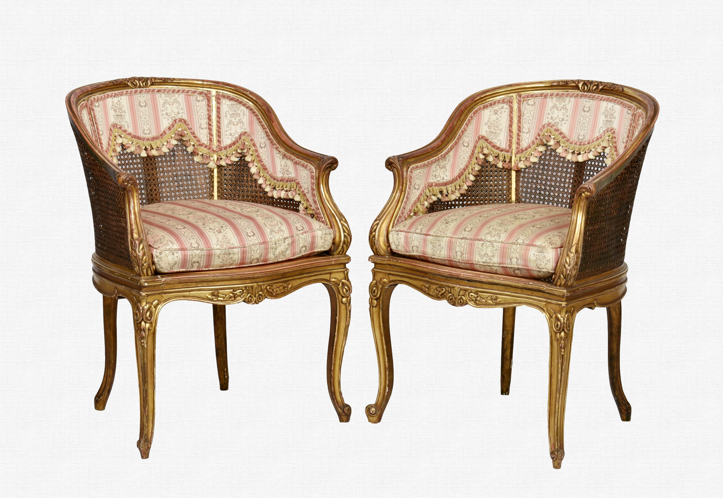 A pair of giltwood chariot-back bergère elbow chairs early 20th century, the shaped, moulded frame