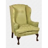 A late 19th century George II style wingback armchair upholstered in pale green silk damask, with