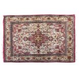 A Tabriz silk rug the central dusky pink shaped medallion with cross shaped inner gol, on an ivory
