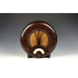 An Art Deco Ecko Type AD75 bakelite radio with circular brown bakelite case, quilted fabric