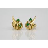 A pair of 18ct yellow gold, emerald and diamond stud earrings of floral form, each set with two