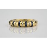 An 18ct yellow gold, sapphire and diamond ring with alternate rows of round cut sapphires and