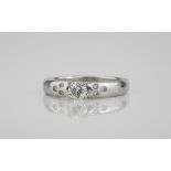 A platinum and diamond ring the central brilliant cut diamond, approx. 0.33ct, over shoulders