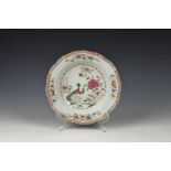 An 18th century Chinese famille rose 'double peacock' dish Qianlong period, with shaped rim, the