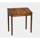 An antique pine clerks tally desk, circa 1800 the sloping top with raised moulded edge and central
