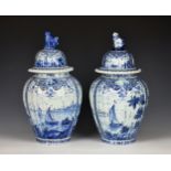 A matched pair of Delft vases and covers 19th century or earlier, of ribbed ovoid form, painted with