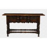 A late 17th century style oak serving table with wide overlapping top, above three carved drawers