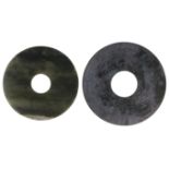 TWO CHINESE ARCHAISTIC JADE BI DISCS the larger carved either side with a stylised dragons, the