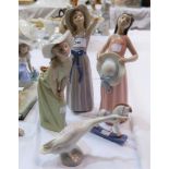 Three Lladro figures of girls posing, with white bonnets, 9-11"; a goose and a rocking horse