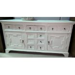 An early 20th century sideboard of 3 frieze and 3 central drawers, 2 side cupboards, in distressed