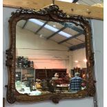 A 19th century wall mirror in 18th century style rectangular carved walnut rococo frame