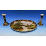 A Noritake oval dish hand painted with river scene and a pair of matching candlesticks