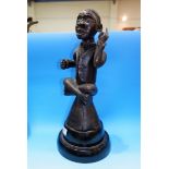 A seated African tribal carved figure with slave collar, height 14.5" on non-matching base