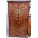 A late 19th/early 20th century Chinese red lacquered wardrobe decorated with gilt figures and