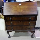 A 1950's walnut bureau with 3 drawers and cabriole legs