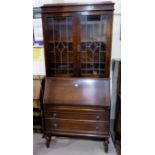 A 1930's oak bureau bookcase with twin leaded glass doors over fall front and 3 drawers