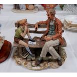 A Capodimonte group: man and boy playing cards on a bench, length 12"