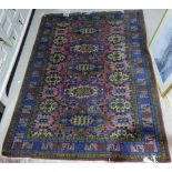 A Persian hand knotted rug with deep red ground, multiple border to the field and central row of