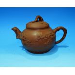 A Chinese terracotta tea pot decorated in relief with flowering branches, impressed mark to base,