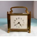 An Art Nouveau brass cased square enamel dial carriage clock with French movement