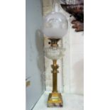 A brass Corinthian column oil lamp with glass reservoir, shade and chimney